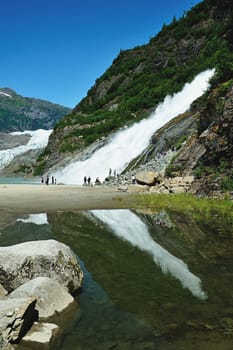 People having fun with waterfall in Alaska