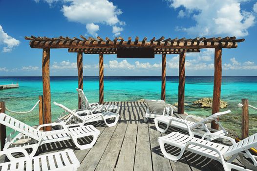 Wood terrace next to beach with blue water