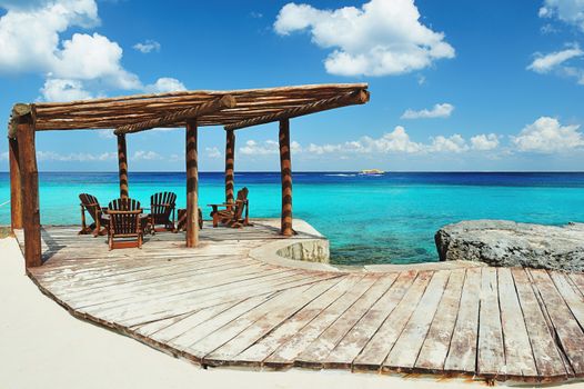 Wood terrace next to beach with blue water