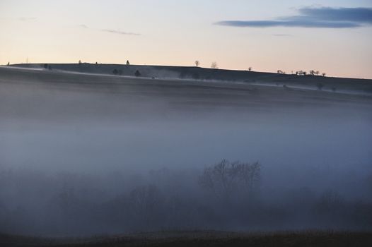 Foggy misty forest hills in a sunset