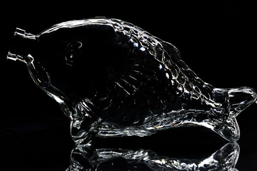 silhouette of fish shape bottle on a black background