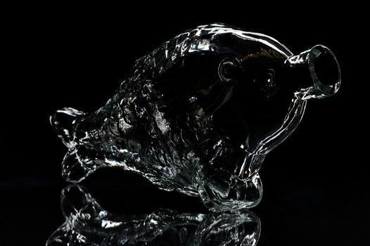 silhouette of fish-shape bottle on a black background