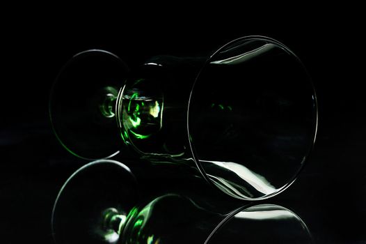silhouette of glass laying down on a black background