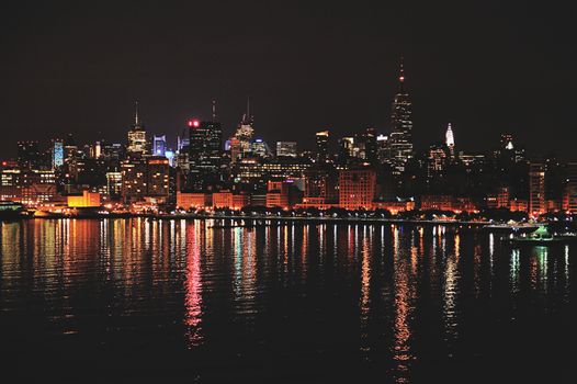 Manhattan skyscrapers lights  reflect in water at night