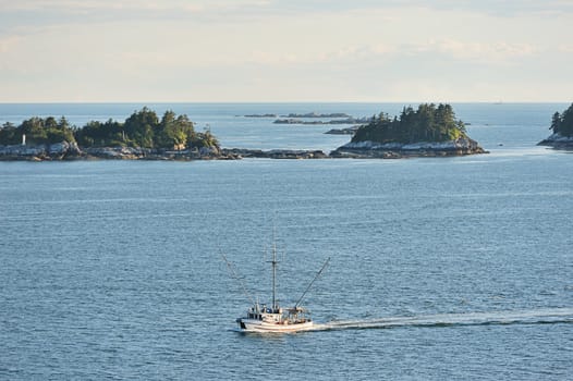 Fishboat moving next to islands and rocks