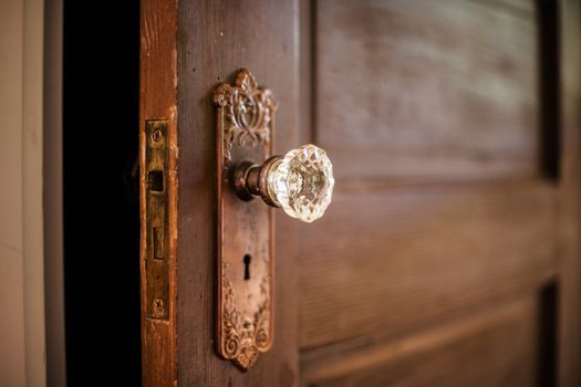 An old door, open with an ornate door knob.