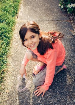 Young girl with brown hair is playing outside.