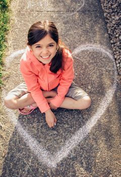 Young girl with brown hair is playing outside.