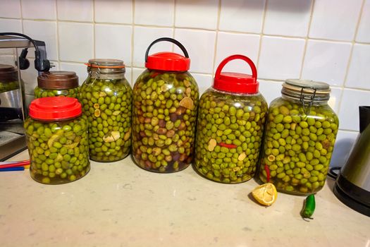 Glass jars with homemade Mediterranean Italian style pickled olives                      