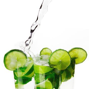 Making mojito cocktails with lime and mint isolated on white background