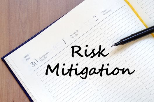 Risk mitigation text concept write on notebook with pen
