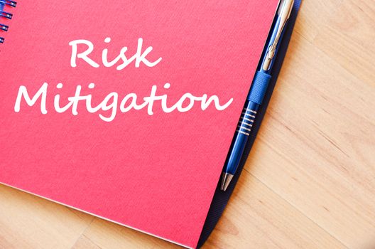 Risk mitigation text concept write on notebook with pen