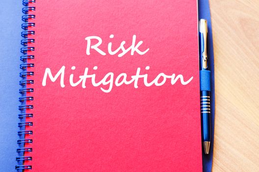Risk mitigation text concept write on notebook with pen