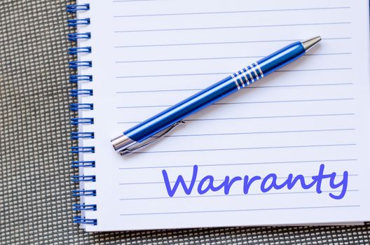 Warranty text concept write on notebook with pen