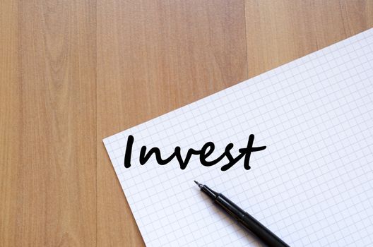 Invest text concept write on notebook with pen