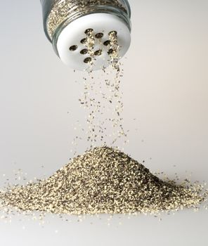 Black Pepper Grains Falling from shaker.