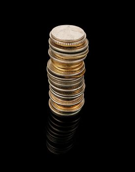 tower of coins isolated on black background, studio shot