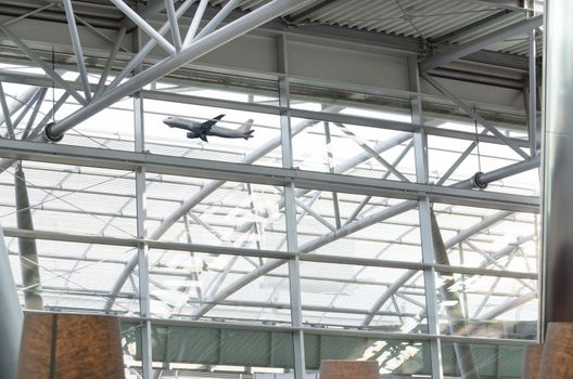 Airport glass roof with steel structure in the background is a take-off Passenger airplane