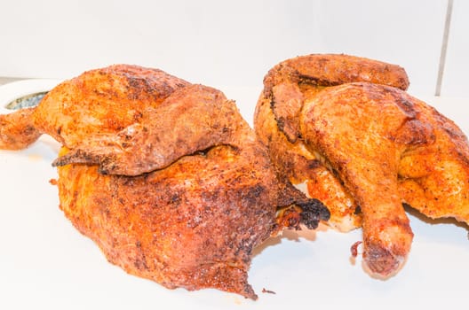 Beautiful brown grilled chicken legs on white plate.