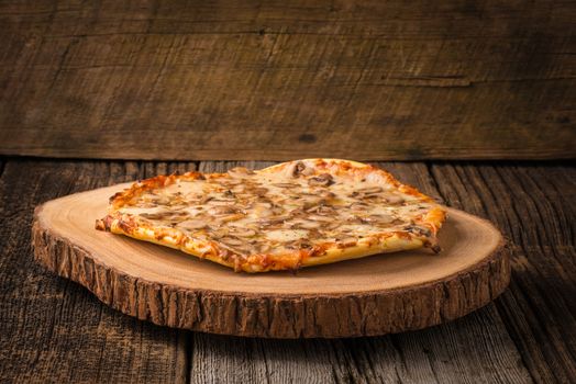 Homemade mushroom pizza presented on a rustic wood cutting board.