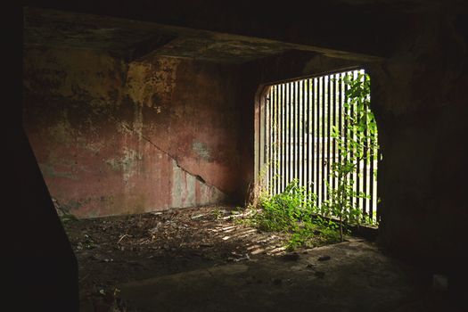 Old prison room with wide window and long metal bars