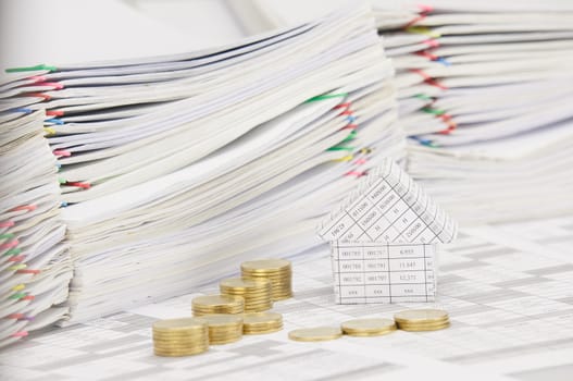 House on finance account have blur step pile of gold coins and pile of document as foreground and background.