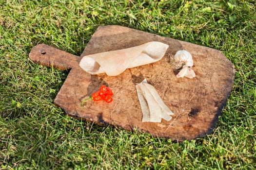 Pig skin slices, garlic and pepper on wooden plate