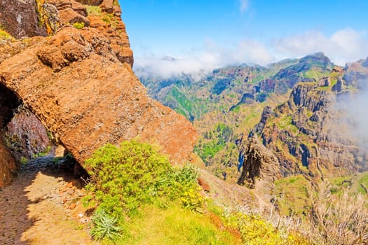 Colorful volcanic mountain landscape with clouds - hiking path from Pico do Arieiro to Pico Ruivo, Madeira, Portugal