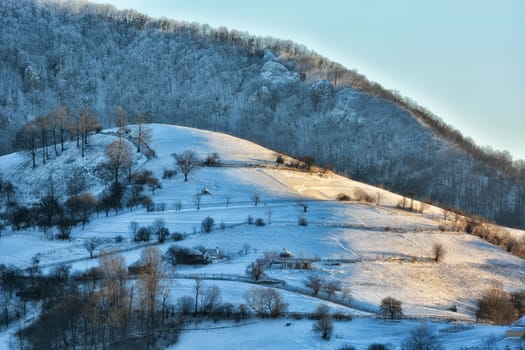 Frozen sunny day of a winter, on wild transylvania hills. Holbav. Romania. Low key, dark background, spot lighting, and rich Old Masters