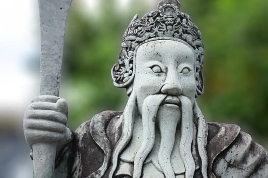 Chinese stone doll with blur green trees background