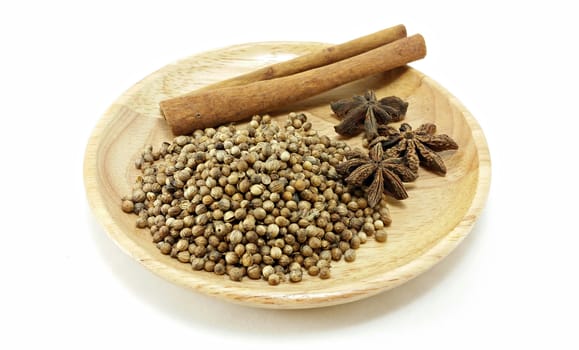 mixed spice (cinnamon, coriander seed, star anise) on wooden plate