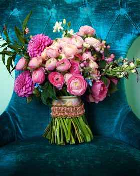 Image of a pink toned bridal bouquet sitting on a chair
