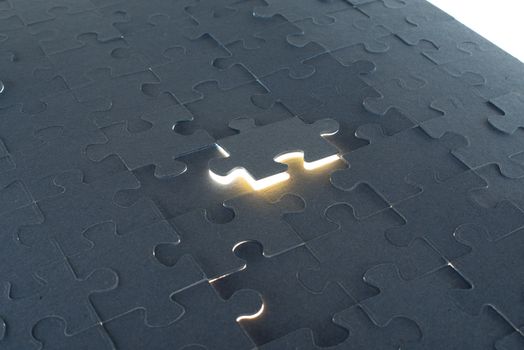 Grey puzzle background with flying piece, close up view