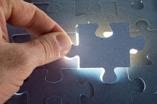 Missing jigsaw puzzle piece with light glow, for completing the final puzzle piece