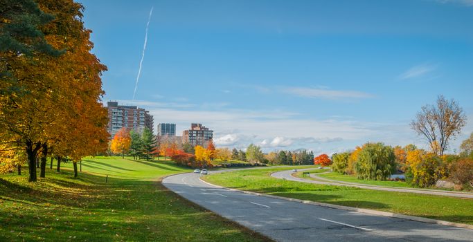 Traffic along Ottawa riverside parkway - runners and riders on winding paved pedestrian path.   Panoramic view following Ottawa River.  Apartments & condos along parkway.