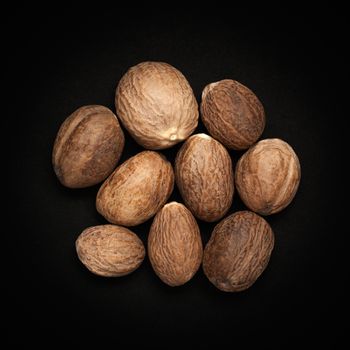 Top view of Organic Nutmeg Seed or Jaiphal (Myristica fragrans) isolated on dark background.