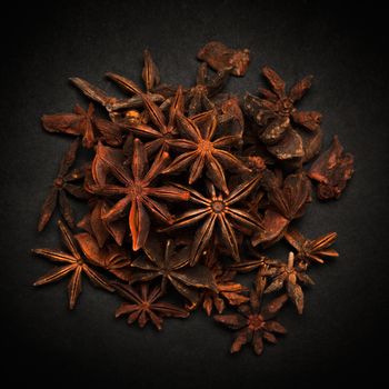 Top view of Organic Star anise or Chakra Phool (Illicium verum) isolated on dark background.