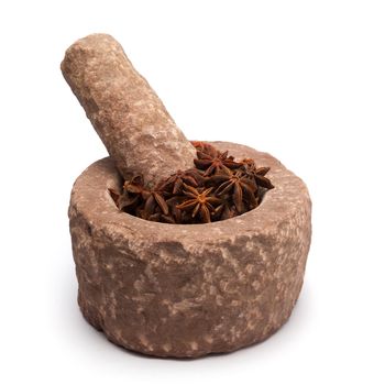 Organic Star anise or Chakra Phool (Illicium verum) in mortar with pestle, isolated on white background.