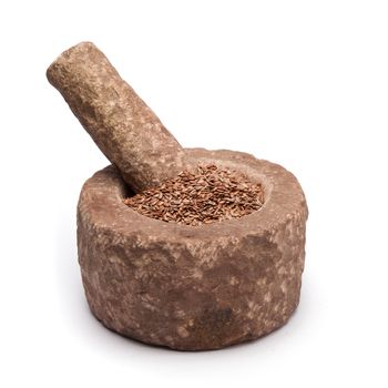 Organic Linseed or Flaxseed (Linum usitatissimum) in mortar with pestle, isolated on white background.