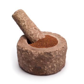 Organic Small Brown Mustard Seeds (Brassica juncea) in mortar with pestle, isolated on white background.