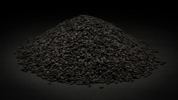 Pile of Organic Black Sesame (Sesamum indicum) on dark background.