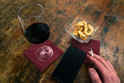 a smoker takes a red wine in the bar