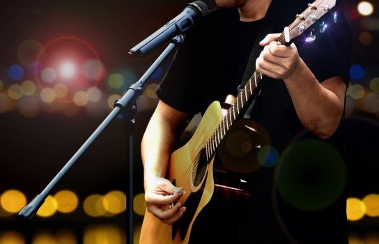 Guitarist on stage performing with acoustic guitar