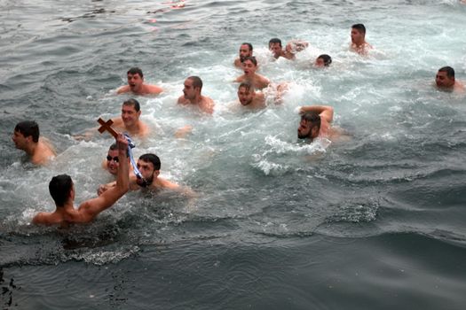 GREECE, Thessaloniki : A swimmer holds in the air a wooden cross he retrieved from the sea, during the blessing of the water ceremony marking the Orthodox Epiphany Day, in Greece's northern port of Thessaloniki on January 6, 2016.Similar celebrations for the Epiphany Day are held across the country and region on river banks, seafronts and lakes.