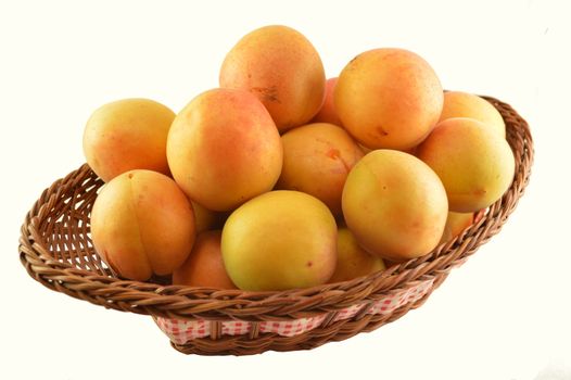 Apricots in a basket isolated on white background.