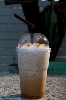 Iced coffee with straw in plastic cup