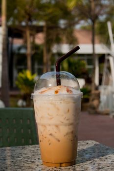 Iced coffee with straw in plastic cup