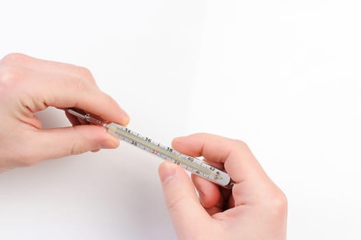 glass thermometer in hands on white background