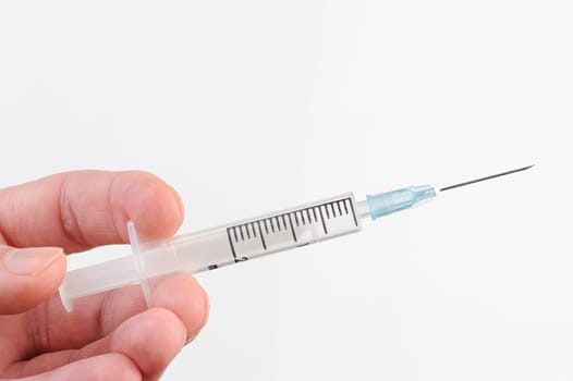 syringe in hand doing vaccination on white