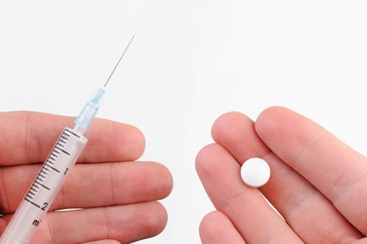  macro thermometer, syringe, and pills on hands on white